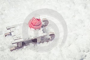 Wooden sleigh toy with cap of Santa Clays on snow with empty space. Concept for New Year or Merry Christmas