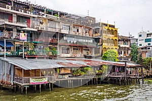 Wooden slums on stilts on the riverside of Chao Praya River in Bangkok