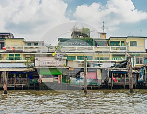 Wooden slums on stilts on the riverside of Chao Praya River