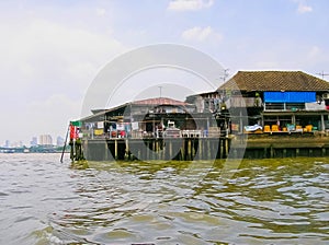 Wooden slums on stilts the riverside of Chao Praya River in Bangkok, Thailand