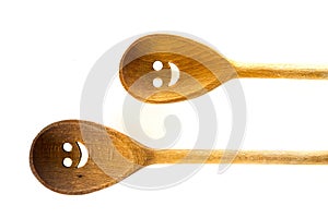 Wooden smiley face spoons on white background