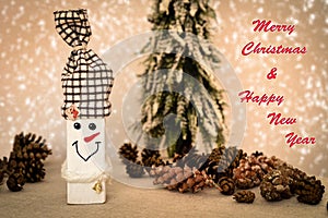 Wooden snowman and pine cones with Merry Christmas and Happy New Year text