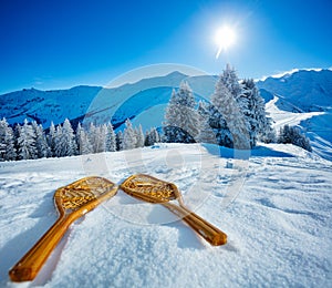 Wooden snowshoes in the snow over mountains and snowy forest