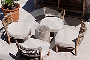 Wooden sofa and coffee tables on cozy stylish modern terrace, patio at a hotel in the sun