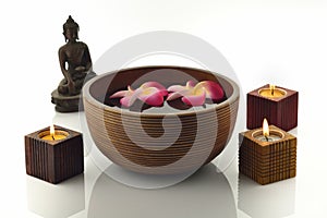 Wooden Spa Bowl on White Background with Buddha Statue,Candles and Flowers