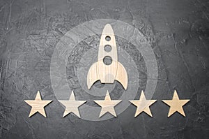 A wooden space rocket and five stars on a concrete background.