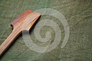 The wooden spatula lie on a green ragcloth