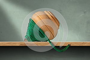 Wooden Spinning Top with Green Rope on a Shelf