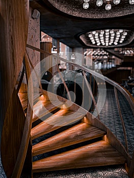 Wooden spiral staircase in a restaurant in front of the hall