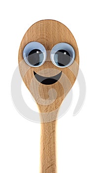 A wooden spoon with a cheerful smiling face.