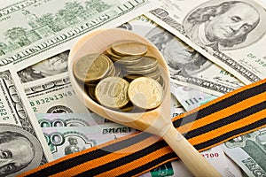 Wooden spoon with coins on a background of money