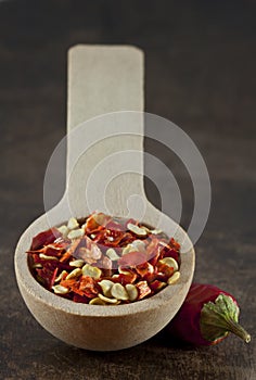 Wooden spoon with dried crushed chili red pepper