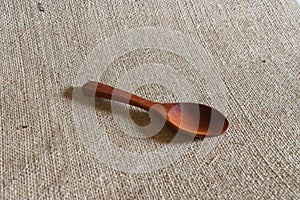Wooden spoon on fabric hemp sack background