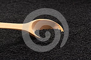 wooden spoon filled with black caraway seeds. food background