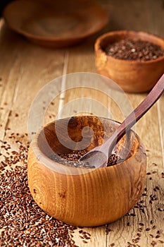 Wooden spoon with flax seeds on rustic background, top view, close-up, shallow depth of field, selective focus