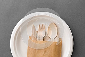 Wooden spoon, fork and knife on paper plate