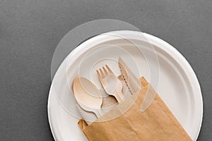 Wooden spoon, fork and knife on paper plate