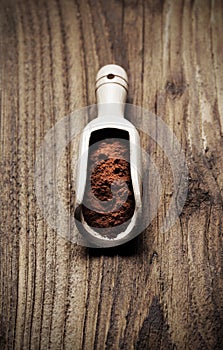 Wooden spoon full of cocoa powder