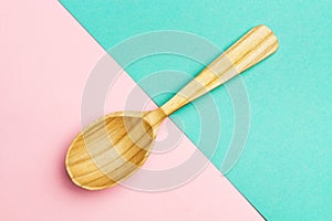 Wooden spoon on a Geometric pink and turquoise background.Spoon with textured tree. Trend Colors . Copy space