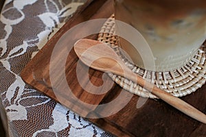 Wooden spoon with glass of coffee latte on table. Vintage crockery, tableware,