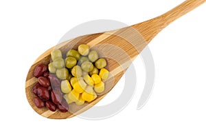 Wooden spoon with green peas, beans, sweet corn on white