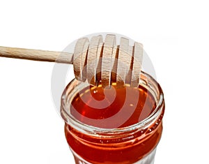 Wooden spoon and a jar of polyfloral bee honey. The concept of beekeeping