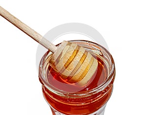 Wooden spoon and a jar of polyfloral bee honey. The concept of beekeeping