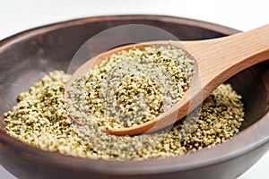 Wooden spoon with legal alimentary hemp seeds in rustic bowl