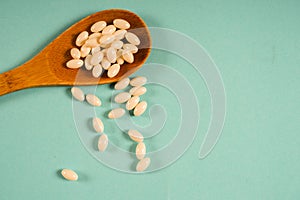 Wooden spoon with a measuring tape on a blue background, diet, healthy lifestyle.