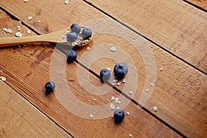 Wooden spoon with oat flakes and blueberry over wooden pattern b