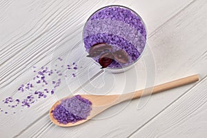 Wooden spoon with pile of purple salt for spa traetment. photo