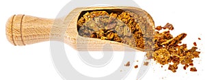 a wooden spoon of propolis granules