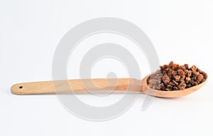 Wooden spoon with raisins on white background.