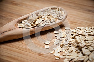 A wooden spoon with rolled oats