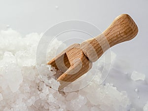 Wooden spoon in sea salt. The crystals of sea salt close up.