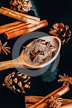 Wooden spoon with star anise, cinnamon sticks, cones, christmas spices background