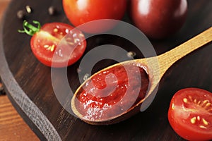 Wooden spoon of sweaty tomato sauce close up on textured