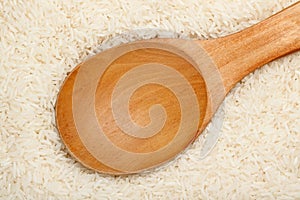 Wooden spoon on Thai fragrant jasmine rice