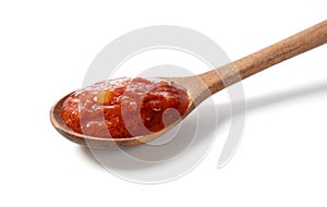 Wooden spoon and tomato sauce on white background