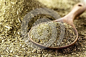 Wooden spoon with yerba mate on background with herb