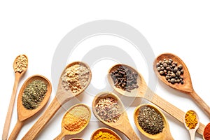 Wooden spoons with different spices on white background