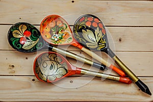 Wooden spoons with floral ornament in traditional folk Russian Khokhloma style on wooden table