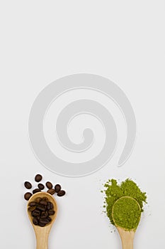 Wooden spoons with green matcha tea powder and coffee beans on white background. comparison concept