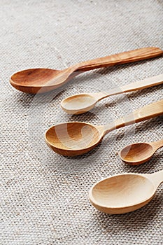 Wooden spoons made of natural wood on burlap fabric as a craft.