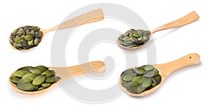 Wooden spoons with peeled pumpkin seeds isolated on white