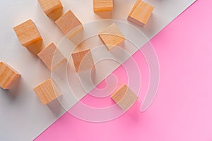 Wooden square block on pink and white background