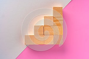 Wooden square block on pink and white background