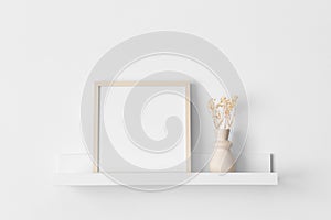 Wooden square frame mockup with a gypsophila decoration on the wall shelf