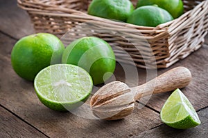 Wooden squeezer and lime on table
