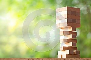 Wooden stack tower from wood blocks toy on greenery blurred background